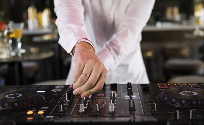 Homem trabalhando como DJ para eventos.