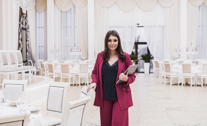 Mulher trabalhando como mestre de cerimônia em evento formal.